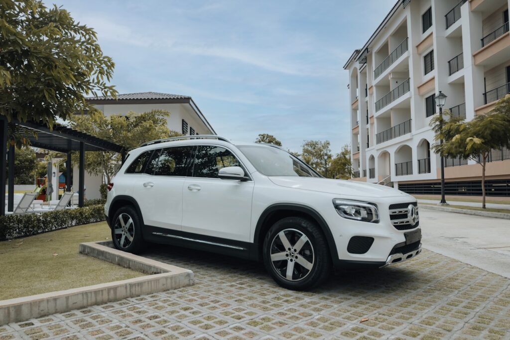 a white car parked on a brick road next to a building