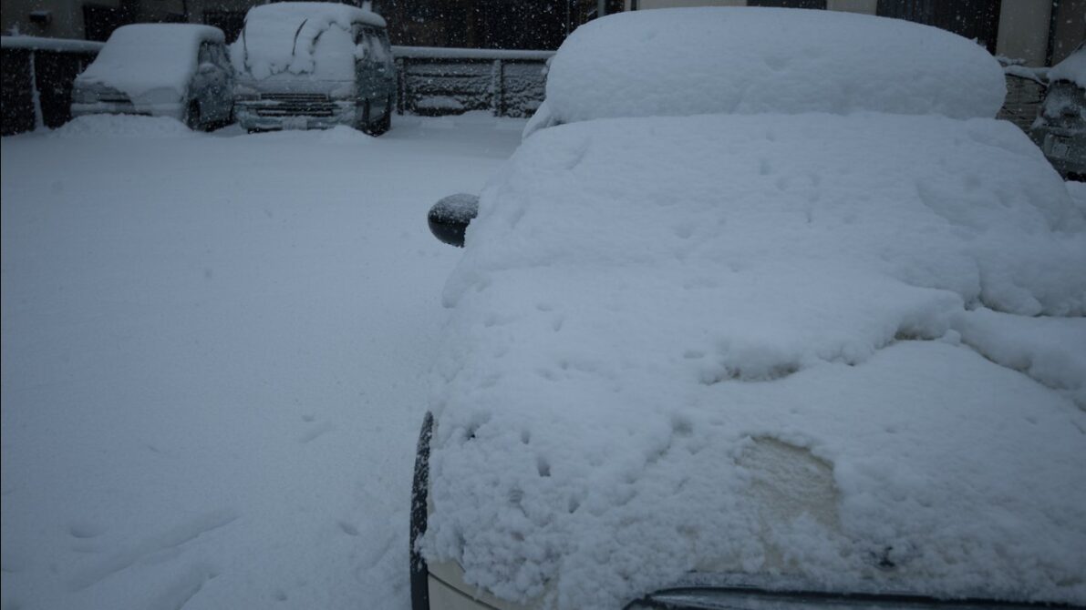 積雪で覆われた日本の住宅街の車